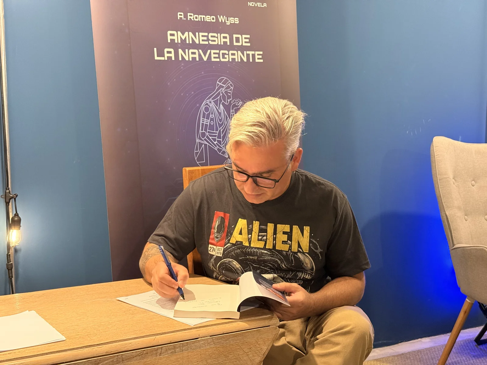 A. Romeo Wyss firmando un ejemplar abierto de Amnesia de la navegante en el encuentro de Valparaíso