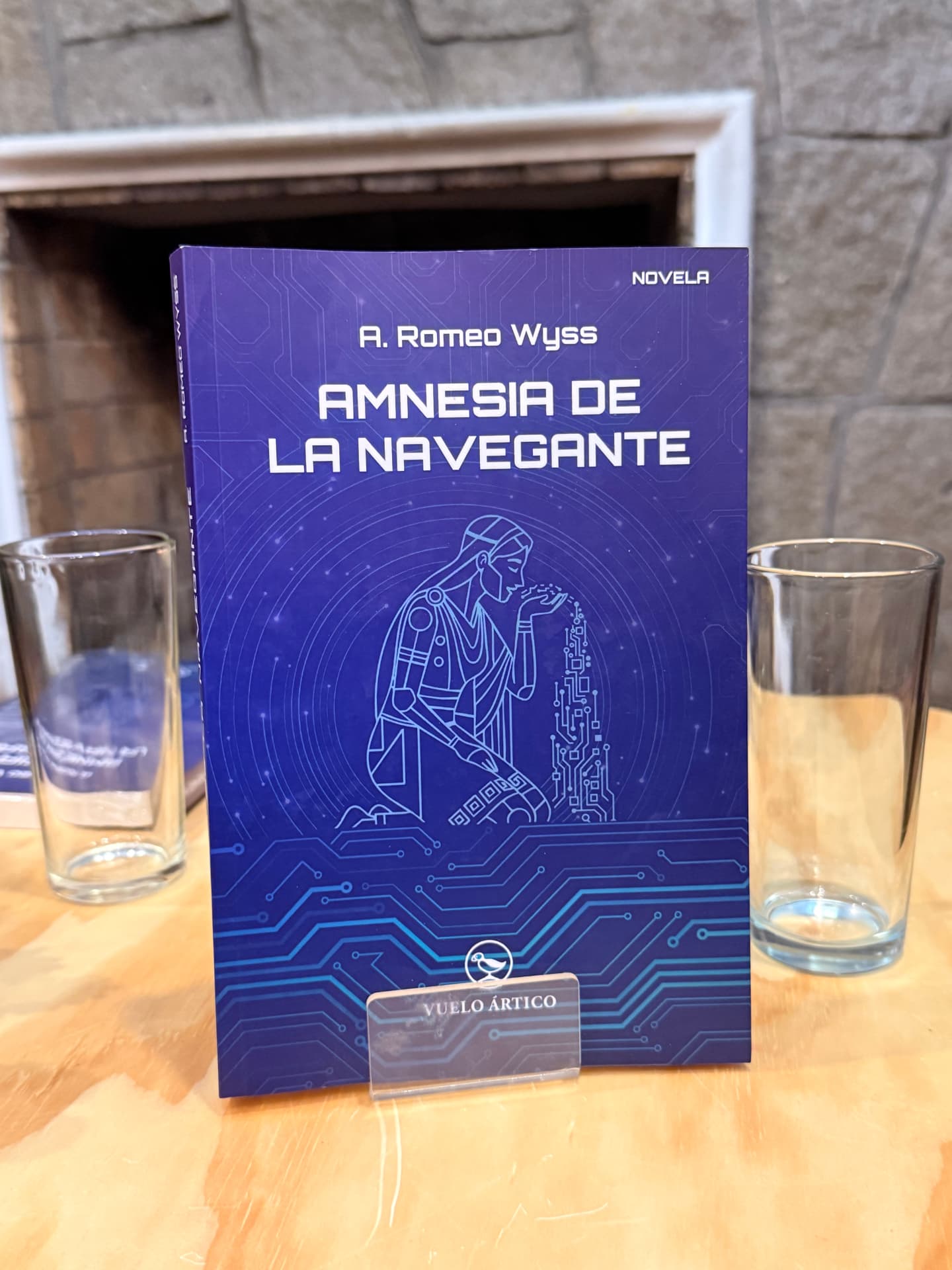 Ejemplar de Amnesia de la navegante junto a un vaso de agua sobre la mesa de la presentación